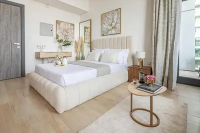 a bedroom with a large white bed and a table at Frank Porter - Regina Tower in Dubai