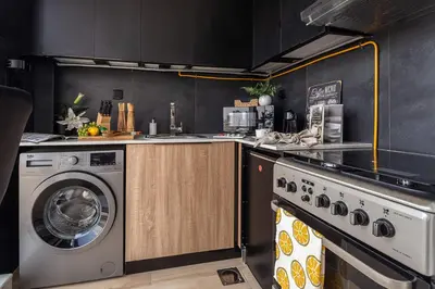 a kitchen with a washing machine and a washer at Frank Porter - Regina Tower in Dubai