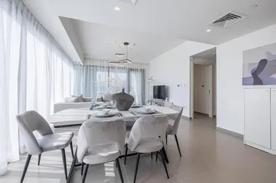 a white dining room with a table and chairs at 3BDR with Maid Room I Downtown I Burj Khaliva View in Dubai