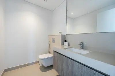 a white bathroom with a sink and a toilet at 3BDR with Maid Room I Downtown I Burj Khaliva View in Dubai