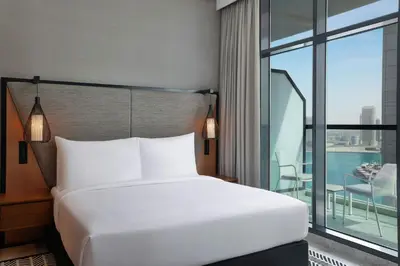 a bed in a hotel room with a large window at The First Collection Waterfront, Dubai, a Tribute Portfolio Hotel in Dubai