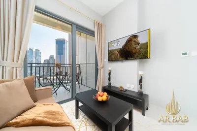 a living room with a couch and a tv on a wall at Arbab Homes Luxury 1BR- Canal View - Damac Zada Tower in Dubai