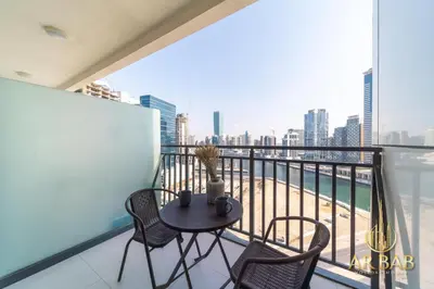 a balcony with a table and chairs and a view of the city at Arbab Homes Luxury 1BR- Canal View - Damac Zada Tower in Dubai