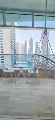 a table and chairs in a room with a view of the city at Spacious Apartment Marina View in Dubai
