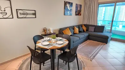 a living room with a couch and a table and chairs at Spacious Apartment Marina View in Dubai