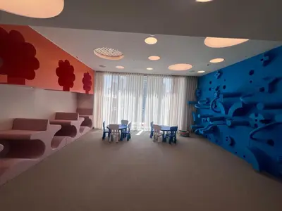 a room with chairs and a table and a blue wall at Forte Downtown Dubai in Dubai