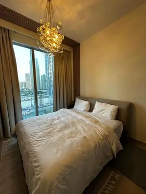a bedroom with a large bed and a chandelier at Forte Downtown Dubai in Dubai