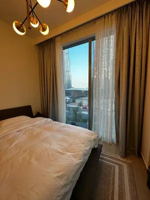 a bedroom with a bed and a large window at Forte Downtown Dubai in Dubai