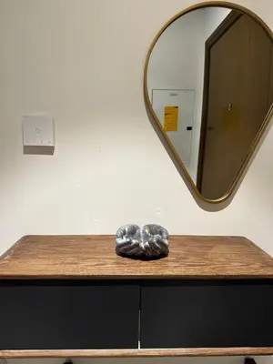 a mirror on top of a wooden table with a sculpture at Forte Downtown Dubai in Dubai