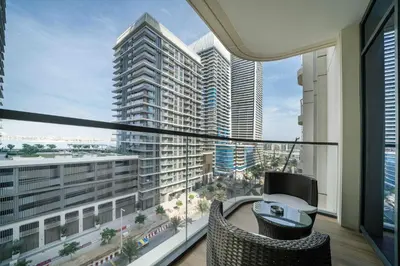 a balcony with a view of a city with tall buildings at Marina Vista 1 Bed with Private Beach and Gorgeous Skyline in Dubai