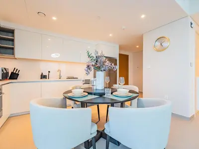 a kitchen and dining room with a table and chairs at Spectacular 2BR in Downtown Views II in Dubai