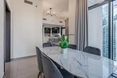 a dining room with a glass table and chairs at Citihome - 1BR at Merano Tower by Damac in Dubai