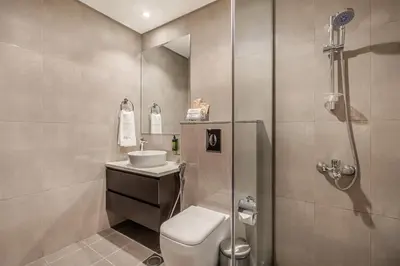 a bathroom with a shower and a toilet and a sink at Citihome - 1BR at Merano Tower by Damac in Dubai