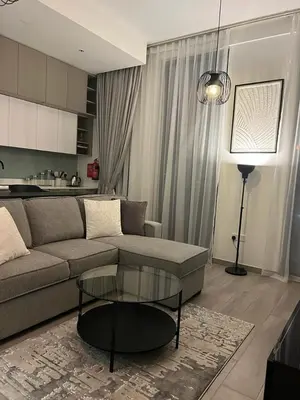 a living room with a couch and a glass table at Dar Alsalam - Premium and Spacious 1BR With Balcony in Noor 2 in Dubai