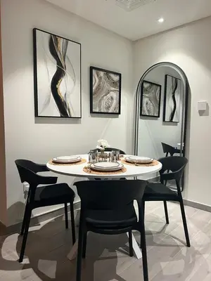 a dining room with a table and chairs and a mirror at Dar Alsalam - Premium and Spacious 1BR With Balcony in Noor 2 in Dubai