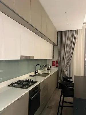 a kitchen with white cabinets and a sink and a stove at Dar Alsalam - Premium and Spacious 1BR With Balcony in Noor 2 in Dubai