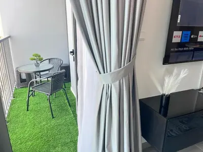 a room with a curtain and a table and chair at Dar Alsalam - Premium and Spacious 1BR With Balcony in Noor 2 in Dubai