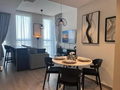 a living room with a table and chairs in a room at Dar Alsalam - Premium and Spacious 1BR With Balcony in Noor 2 in Dubai