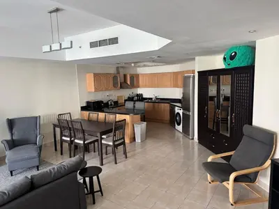 a kitchen and living room with a table and chairs at Stylish Marina View Apartment in Dubai
