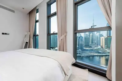 a bedroom with a bed and a large window at Waves Holiday Homes - 15 Northside, Tower 1, Two Bedroom in Dubai