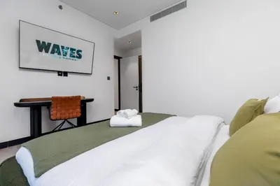 a bedroom with a bed and a desk in a room at Waves Holiday Homes - 15 Northside, Tower 1, Two Bedroom in Dubai