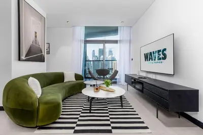 a living room with a green couch and a table at Waves Holiday Homes - 15 Northside, Tower 1, Two Bedroom in Dubai