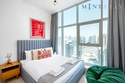 a bedroom with a bed and a large window at Continental Tower, Dubai Marina - Mint Stay in Dubai