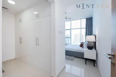 a bedroom with a bed and a sliding glass door at Continental Tower, Dubai Marina - Mint Stay in Dubai