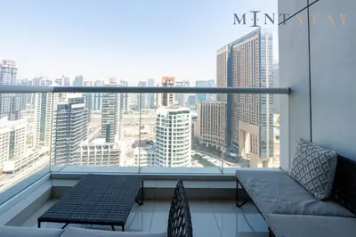 a balcony with a couch and a view of a city at Continental Tower, Dubai Marina - Mint Stay in Dubai