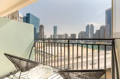 a balcony with two chairs and a view of a city at 1BR Zada Tower l Two Balconies & City Views in Dubai