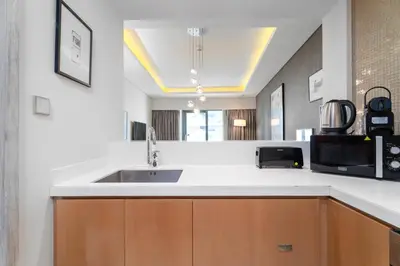 a kitchen with a sink and a microwave at ALiving Classy 1BR I Paramount Towers, Business Bay- 6105 in Dubai