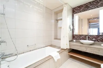 a bathroom with a tub and a sink and a mirror at ALiving Classy 1BR I Paramount Towers, Business Bay- 6105 in Dubai