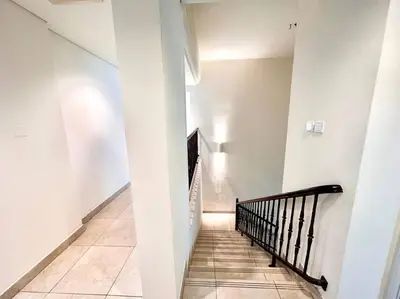 a hallway with white walls and a black staircase at Golf Facing 5Bedroom Villa in Novelia Village in Dubai