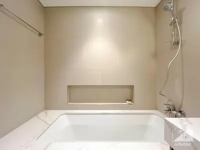 a white bath tub in a bathroom with a shower at Luxurious stay Dubai Creek Balcony & View in Dubai