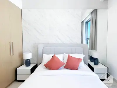 a bedroom with a white bed with two red pillows at Luxurious stay Dubai Creek Balcony & View in Dubai