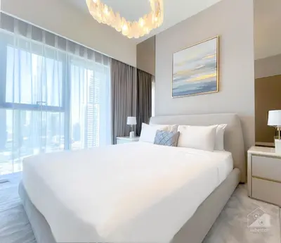 a white bedroom with a large bed and a large window at Luxury Burj Royale Burj Khalifa & Fountain view in Dubai