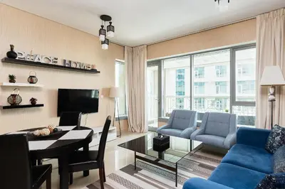 a living room with a blue couch and a table at Bellavista - 1 BR - with Extra Room - Partial Fountain View in Dubai