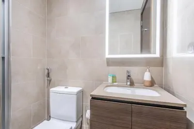a bathroom with a sink and a toilet and a mirror at STAY BY LATINEM Luxury 2BR Holiday Home CV A814 near Burj Khalifa in Dubai