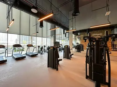 a gym with rows of exercise equipment in a room at Oraya - Modern Apt 5 min walk to Dubai Mall & Burj Views in Dubai