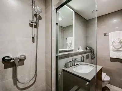 a bathroom with a shower and a sink and a toilet at Trophy - Cozy Elegant Suites in Dubai