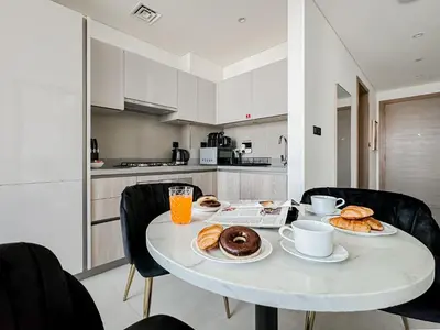 a white table with plates of pastries on it in a kitchen at Trophy - Cozy Elegant Suites in Dubai