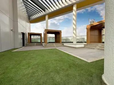 an outdoor patio with green grass and a building at Trophy - Cozy Elegant Suites in Dubai