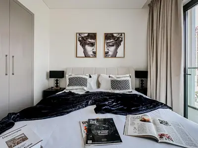 a bedroom with a bed with two publications on it at Trophy - Cozy Elegant Suites in Dubai
