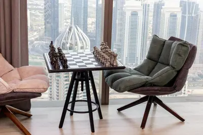 a chess board and two chairs in a room with a window at High floor Luxury 2BR - Dubai Marina Gate in Dubai