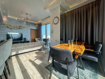 a dining room with a table and a television at High floor Luxury 2BR - Dubai Marina Gate in Dubai