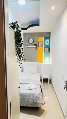 a small room with a bed and a plant at Glamorous Partition Room in Barsha 1 Near Metro in Dubai