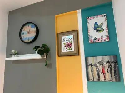 a room with a door and a clock and pictures at Glamorous Partition Room in Barsha 1 Near Metro in Dubai