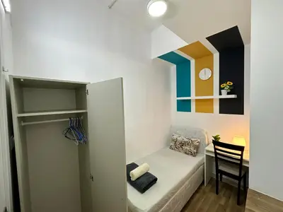 a small room with a small bed and a chair at Charming Partition Room in Barsha Heights Near ICM in Dubai