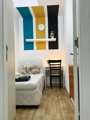 a bedroom with a bed and a desk with a chair at Charming Partition Room in Barsha Heights Near ICM in Dubai