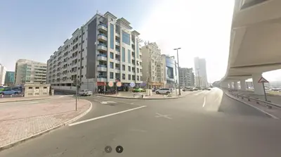 an empty street in a city with tall buildings at Lovely Partition Room in Barsha 1 Near Metro in Dubai